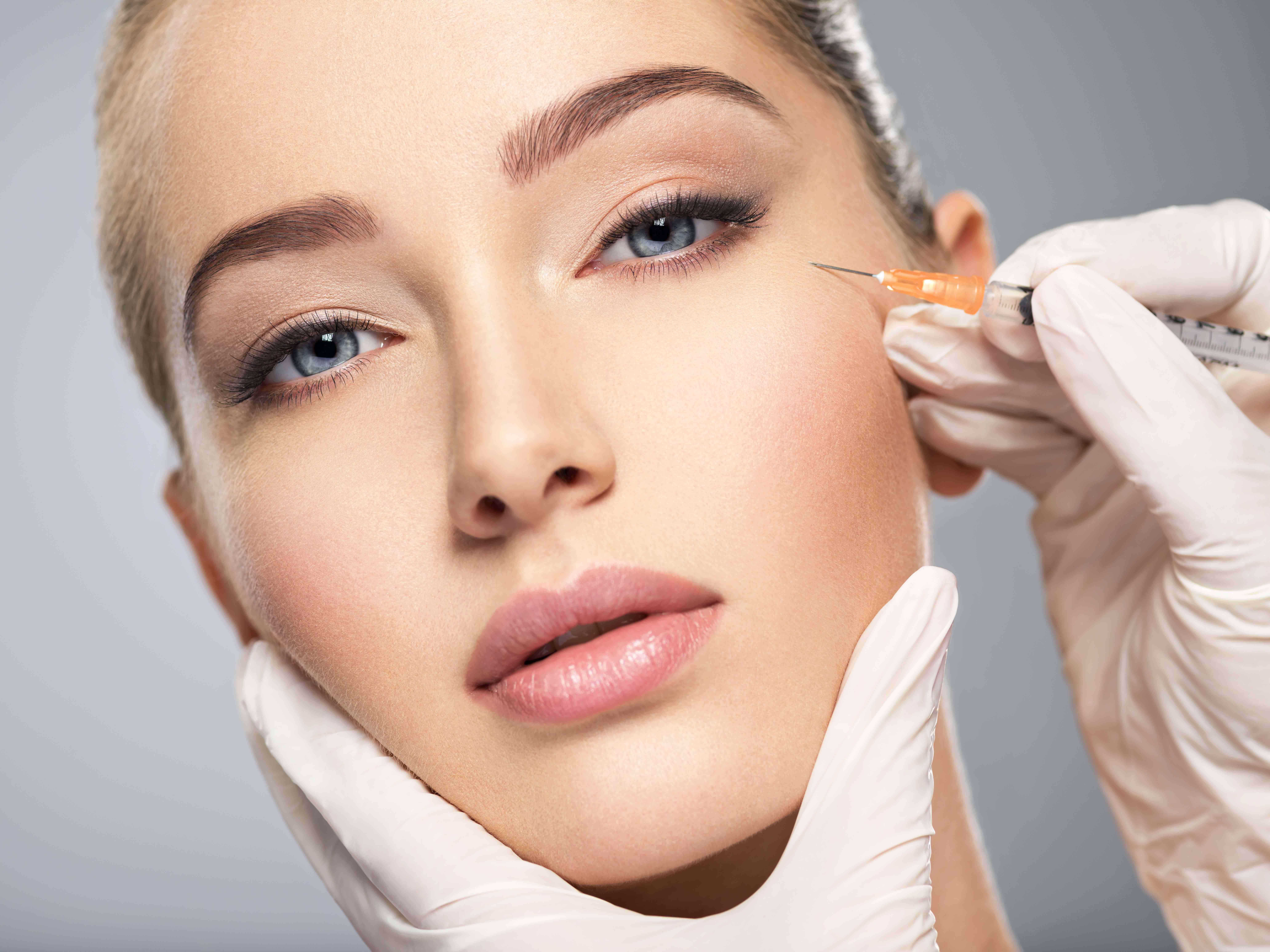 Woman getting cosmetic injection of botox in cheek, closeup. Woman in beauty salon | Skin Parlour