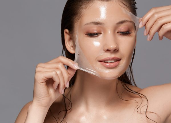 Attractive woman removing moisturizing mask and looking at camera | Skin Parlour