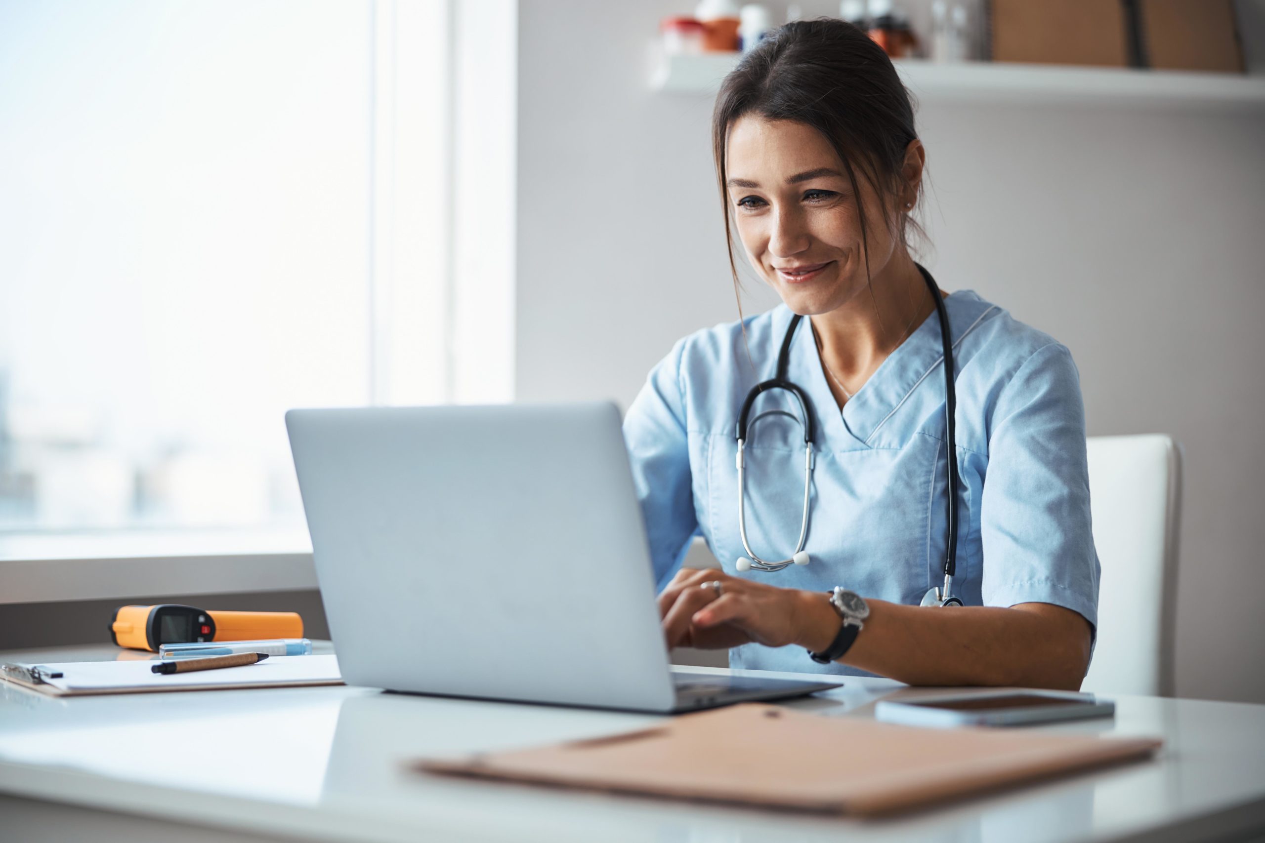Portrait of a female doctor watching laptop | Health Coaching | Skin Parlour in Pensacola, FL